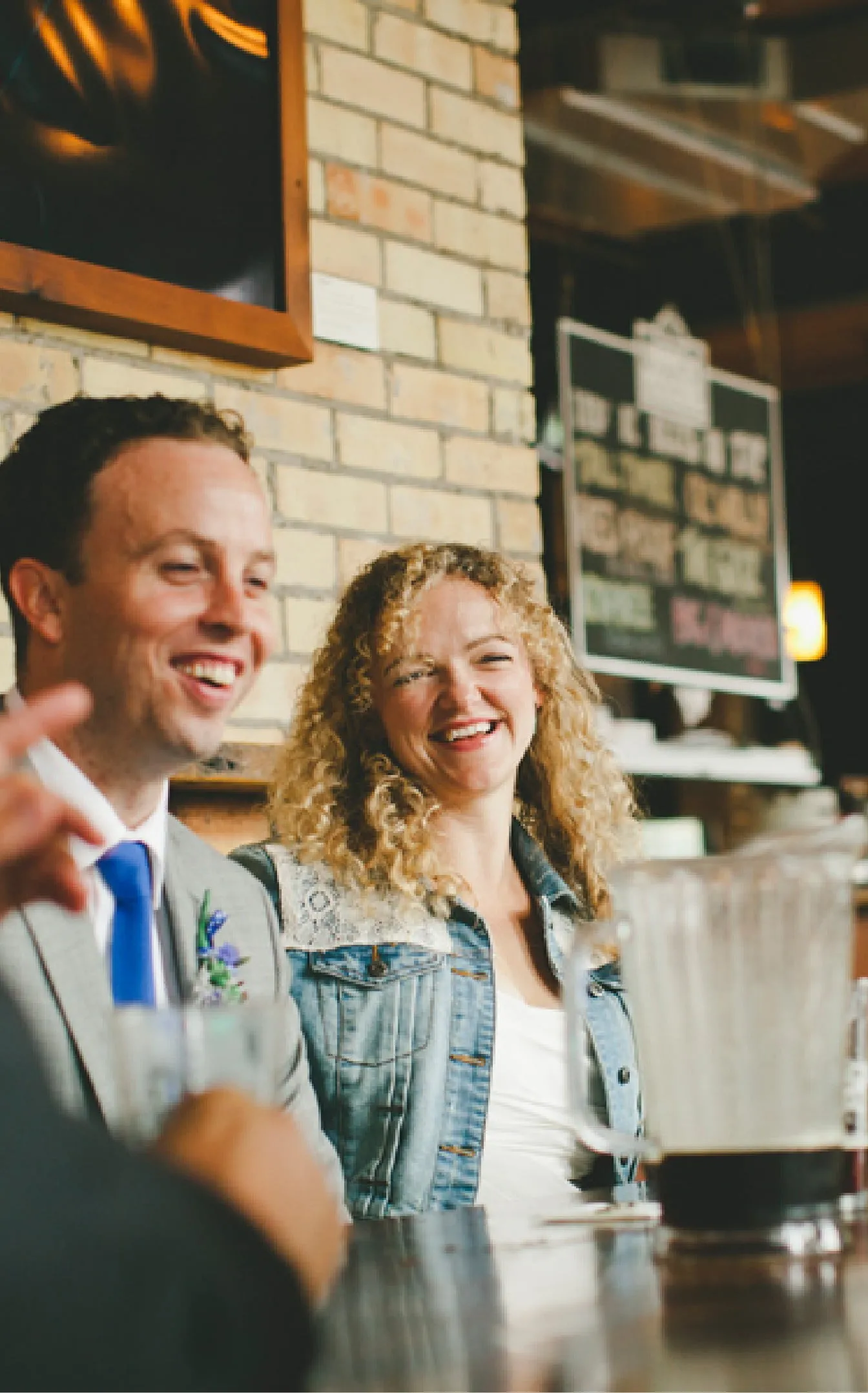 Suzy and Trevor sitting around a table laughing with friends and family - dram adventure